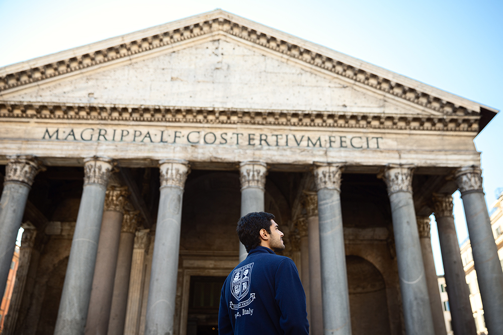 Student in John Cabot logo in front of the Pantheon in Rome, Italy